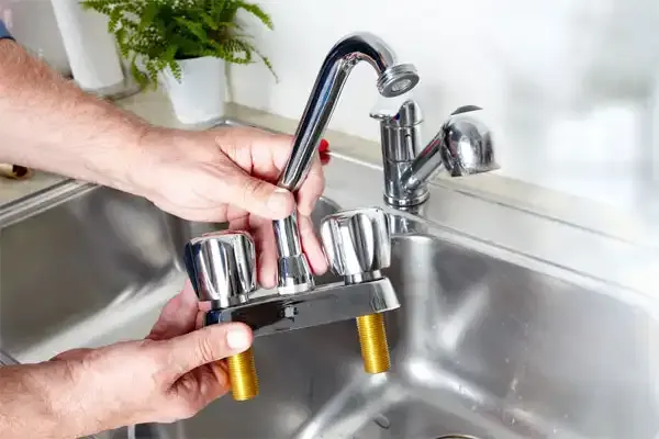 Plumber working under a kitchen sink